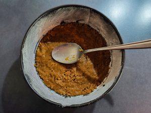 Spekulatius-Buttermischung als Boden in Kuchenform verteilen